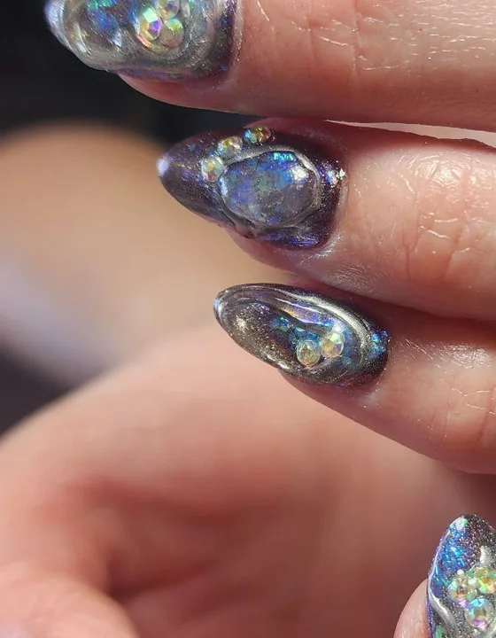 Uñas almendradas con acabado tornasol y cristales, trabajo publicado por Dinux